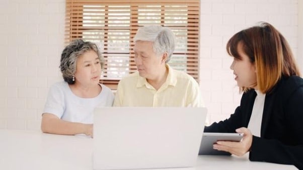 an elderly couple discussing their will with a lawyer